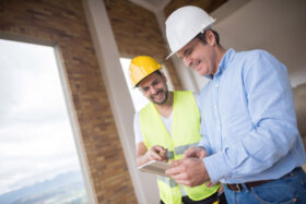 Two construction managers reviewing their tablet